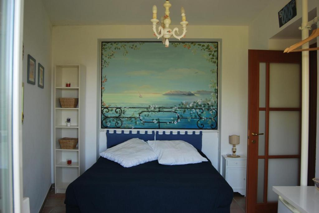 索伦托Sorrento Studios Lemons Hill的卧室配有一张蓝色的床,墙上挂着一幅画