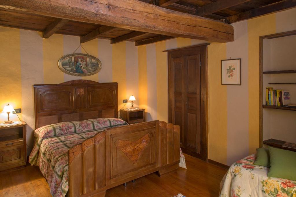 Portula奥罗二伯塔农庄公寓的一间卧室配有一张大木床和两盏灯。