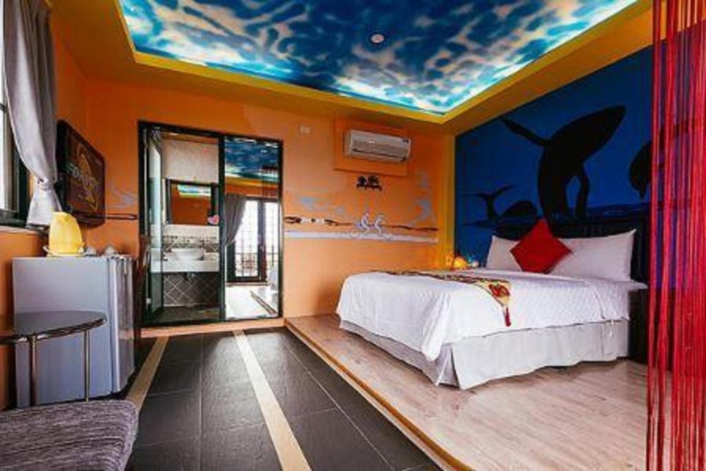 恒春古城幸福垦丁的一间卧室配有一张天花板上绘画的床