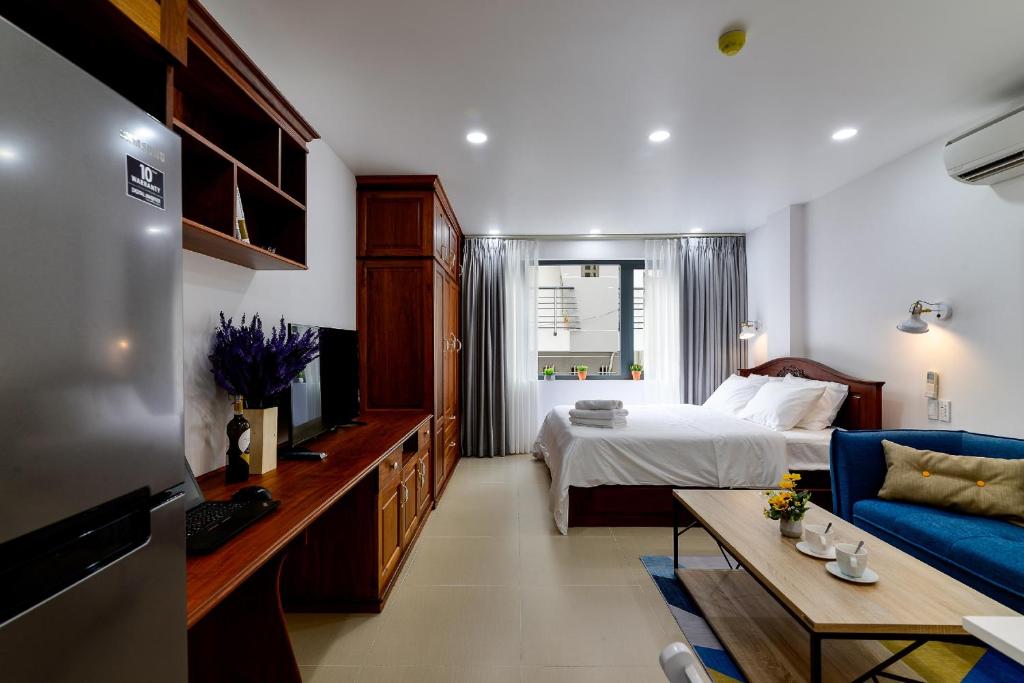 胡志明市Woody House Saigon Center的一间卧室配有一张床和一张蓝色的沙发