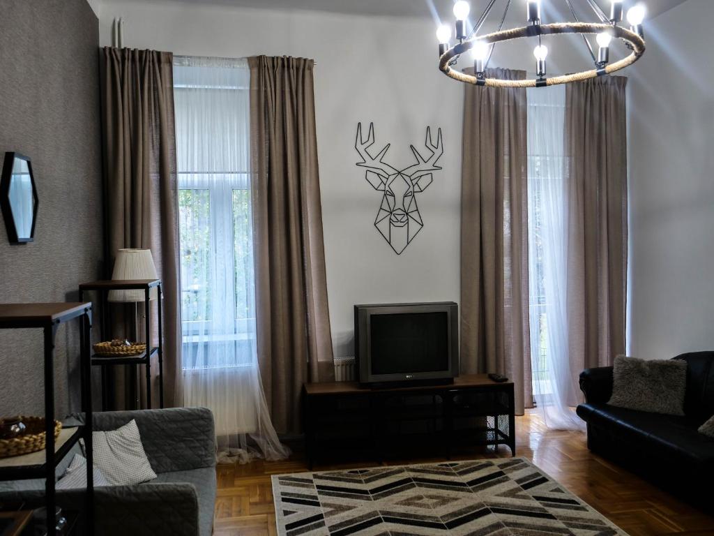 卢布林森特旅馆的客厅配有电视,墙上挂着鹿头