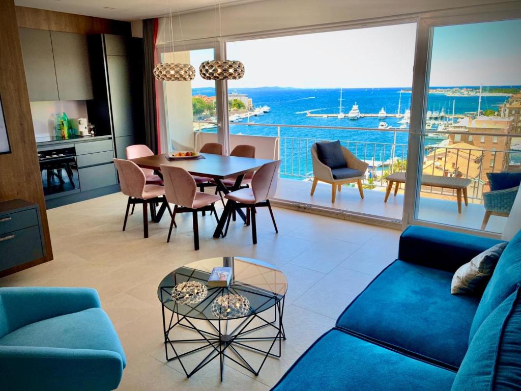 扎达尔ZADAR Panorama Sea View Apartments的客厅配有蓝色的沙发和桌子