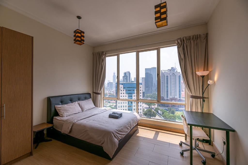吉隆坡Rex Ollie @ 231 TR Suite的一间卧室配有一张床、一张书桌和一个窗户。