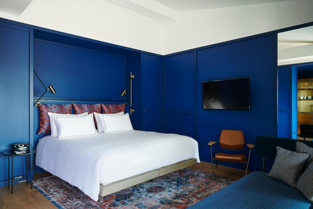 巴黎Hôtel Le Ballu的蓝色卧室,配有床和椅子