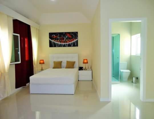 丰沙尔São Francisco Accommodation的一间白色卧室,配有床和一间浴室