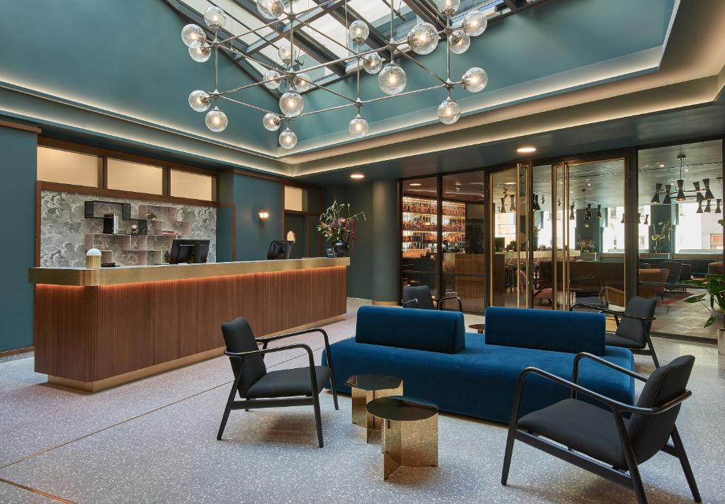 慕尼黑Hotel MIO by AMANO的大堂设有蓝色的沙发和椅子