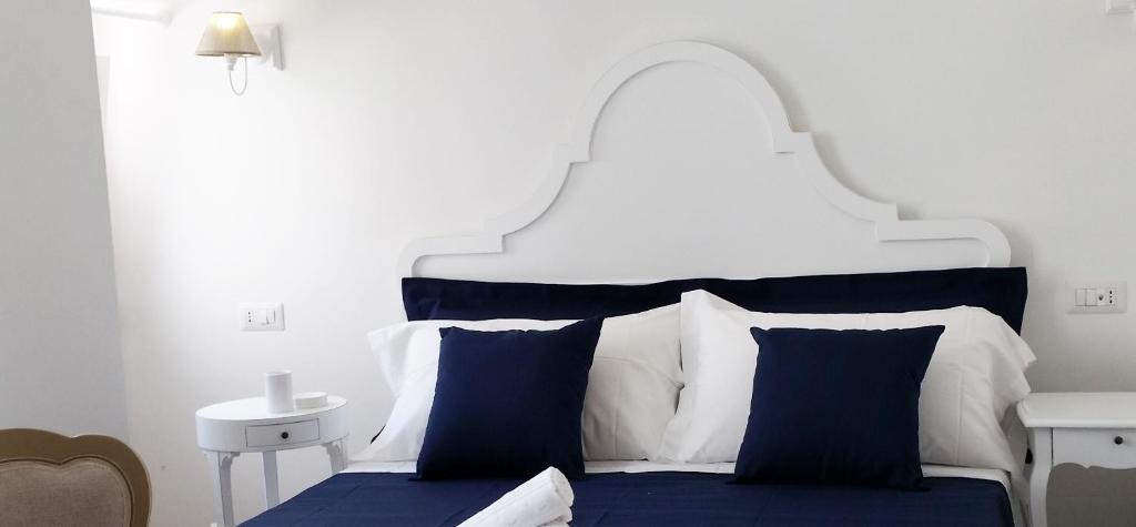 莫诺波利Affittacamere La Cattedrale的白色和蓝色的床,配有蓝色的床单和枕头