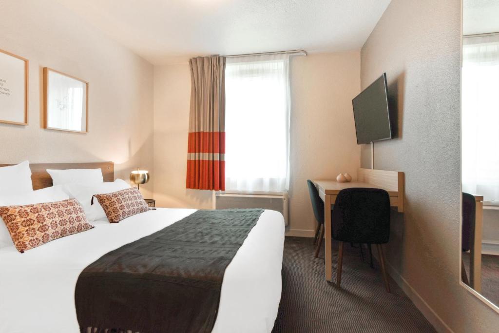 里尔Appart'City Confort Lille - Euralille的配有一张床和一张书桌的酒店客房