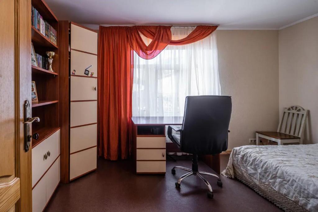 里加Room in a Private House 10 min from Airport Riga的一间卧室配有书桌、床和窗户。