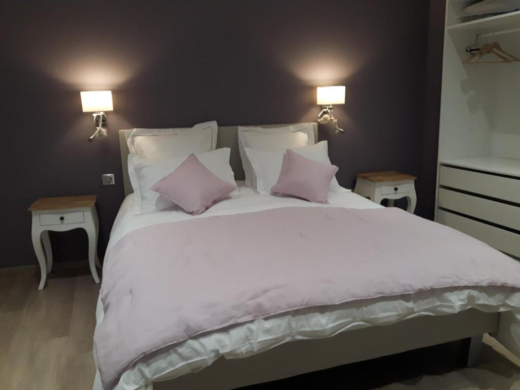 科尔马L'Ourson的卧室配有带粉红色枕头的大型白色床