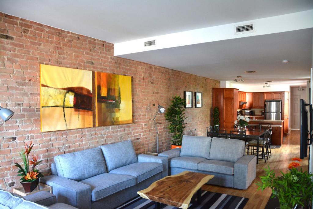 蒙特利尔蒙特利尔梅特蒙皇家公寓的客厅设有蓝色的沙发和砖墙