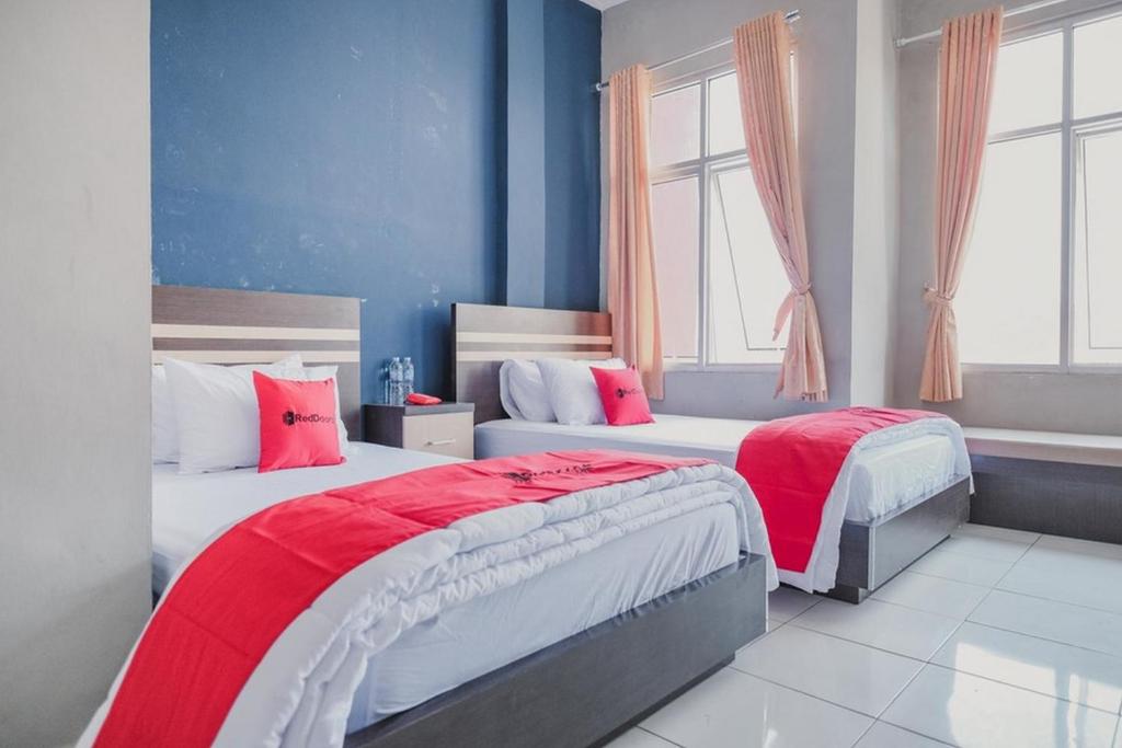 班达楠榜RedDoorz @ Jalan Hayam Wuruk Lampung 2的配有两张床铺的蓝色墙壁和窗户