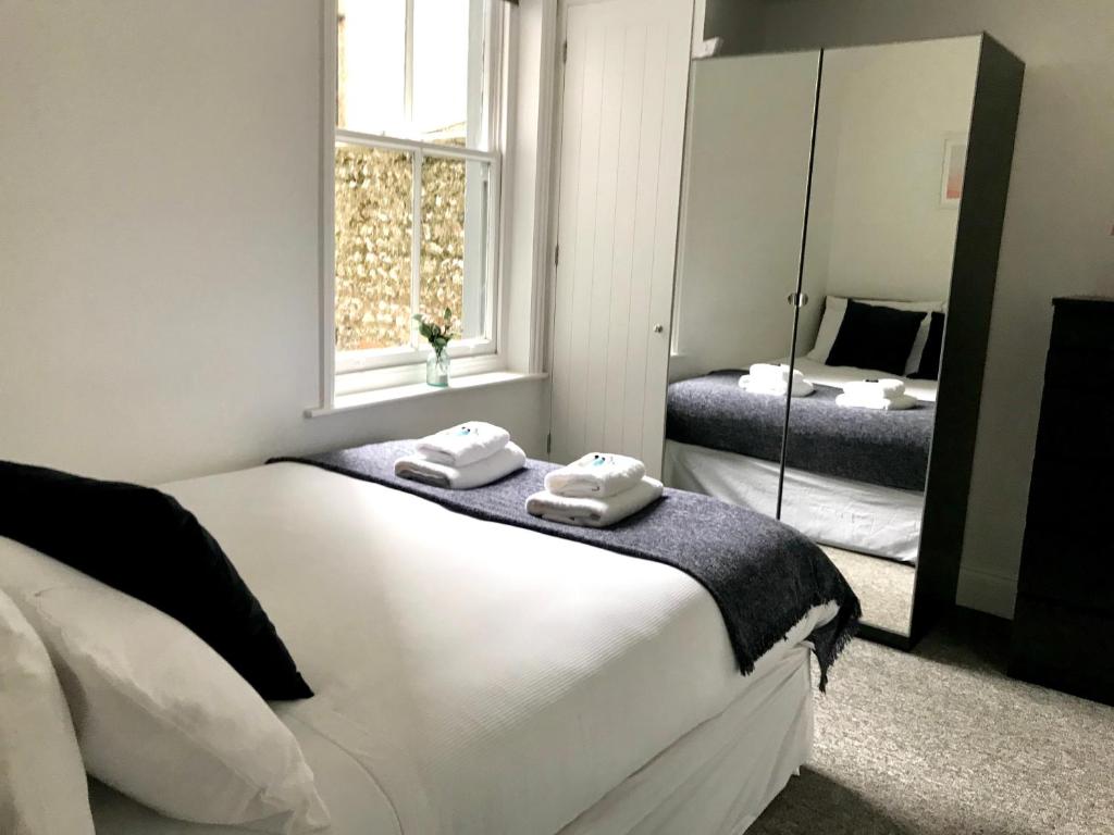 布莱顿霍夫Brighton 2 Bed 2 Bath & Terrace的卧室配有一张白色大床和镜子