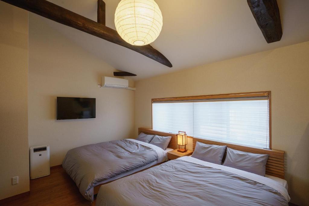 宫津市Coto的一间卧室设有两张靠窗的床。