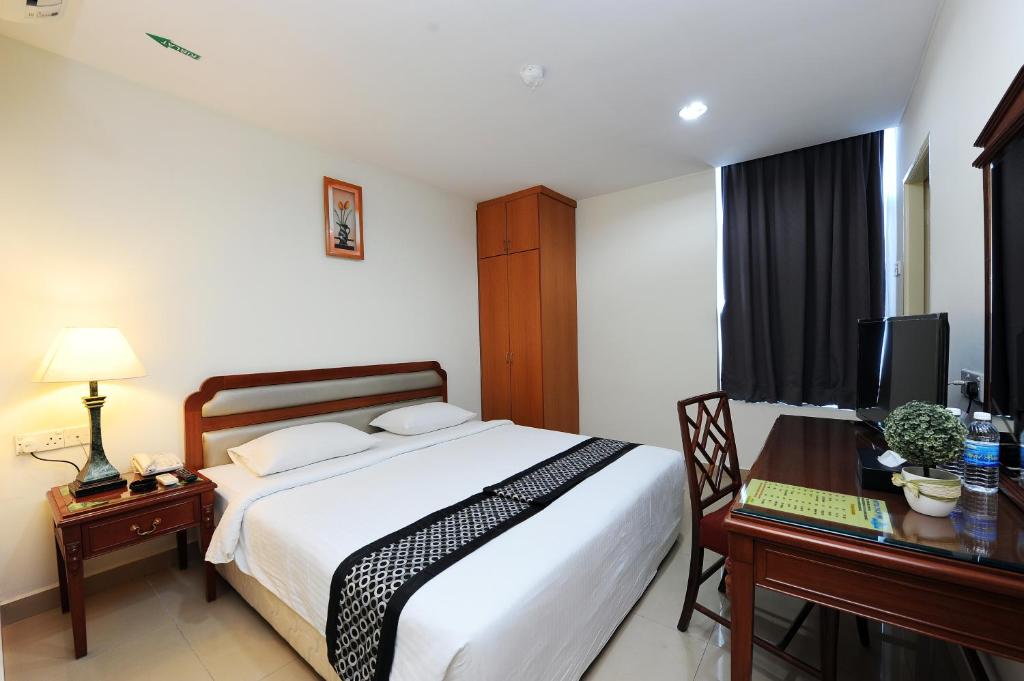 安邦Palm Inn Ampang Point的一间卧室配有一张床和一张带电脑的书桌