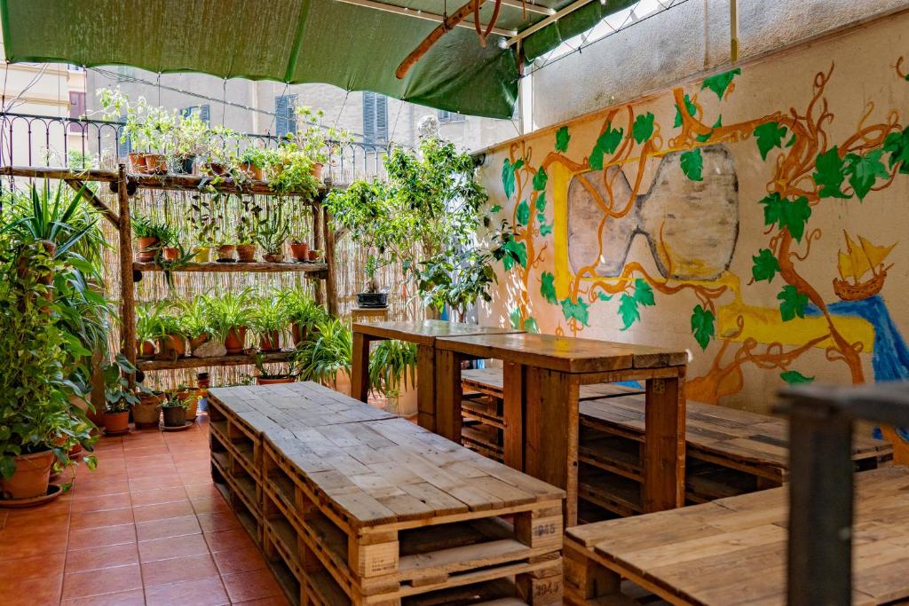 巴勒莫A Casa di Amici的墙上有桌子和盆栽植物的房间