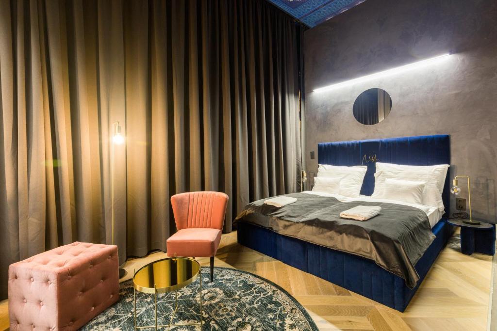 布达佩斯Noble Boutique Hotel - Adults Only的一间卧室配有一张床、一把椅子和一张桌子