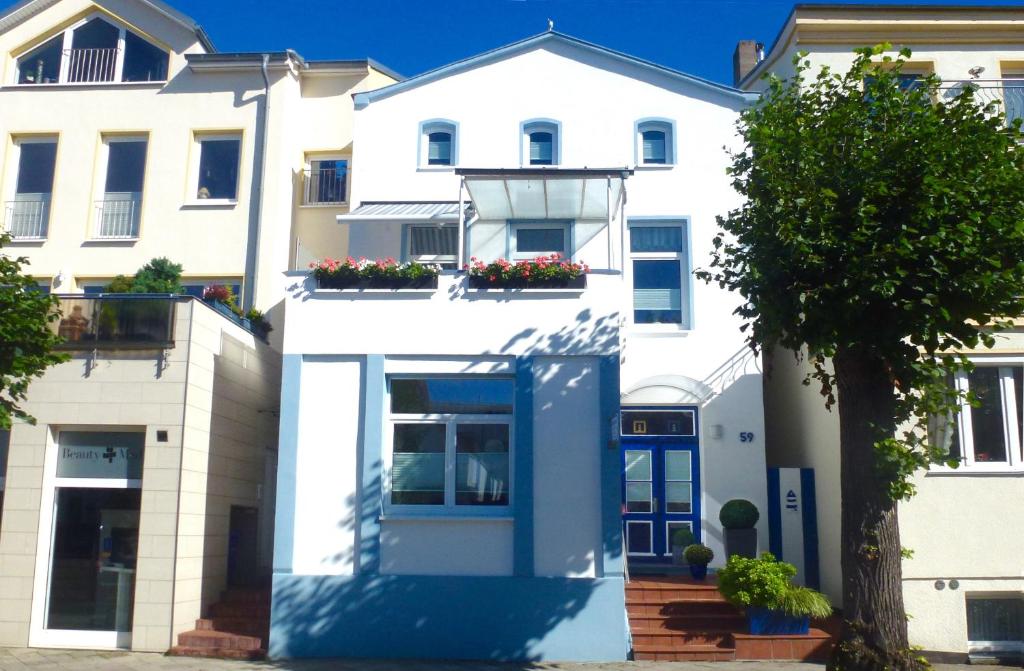 瓦尔内明德Haus der kurzen Wege的白色的公寓楼,设有蓝色的门