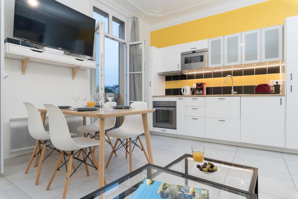 土伦L'Olivaroise的厨房配有白色橱柜和桌椅