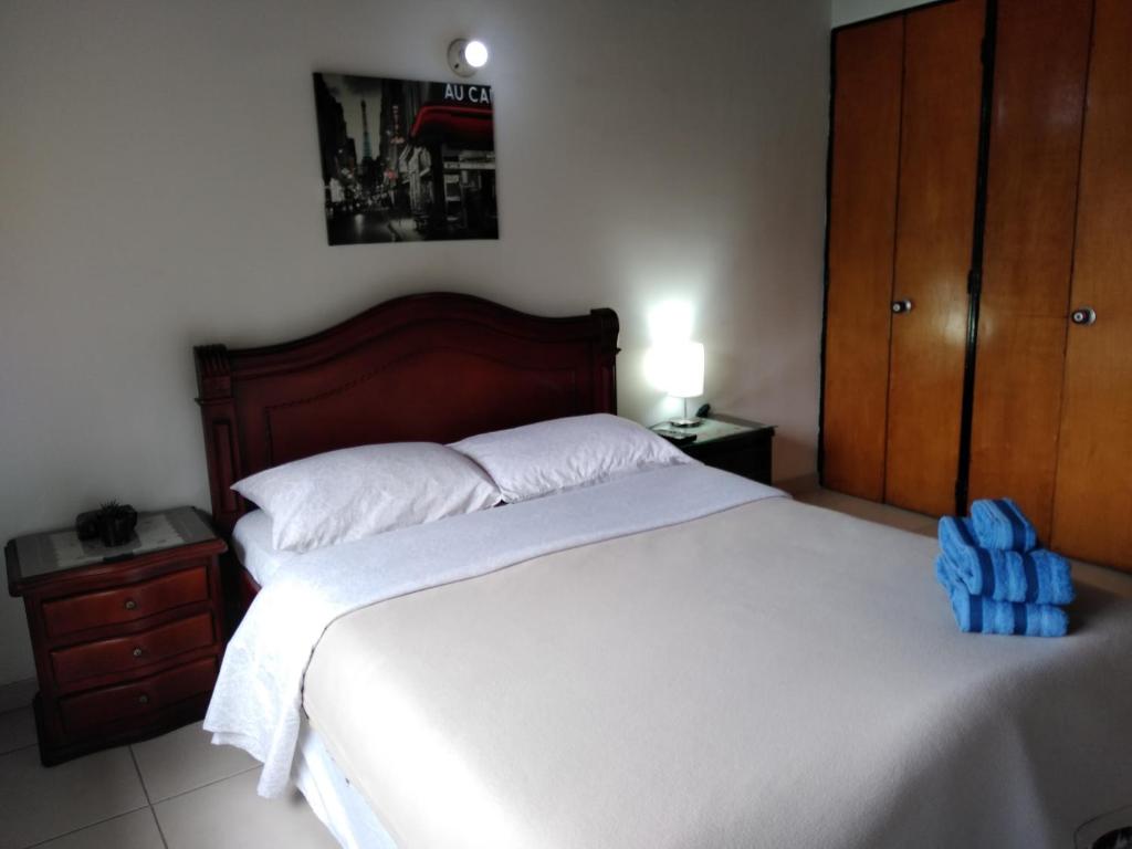 波哥大Hostal Norma101的一间卧室配有一张大床,上面有蓝色的背包