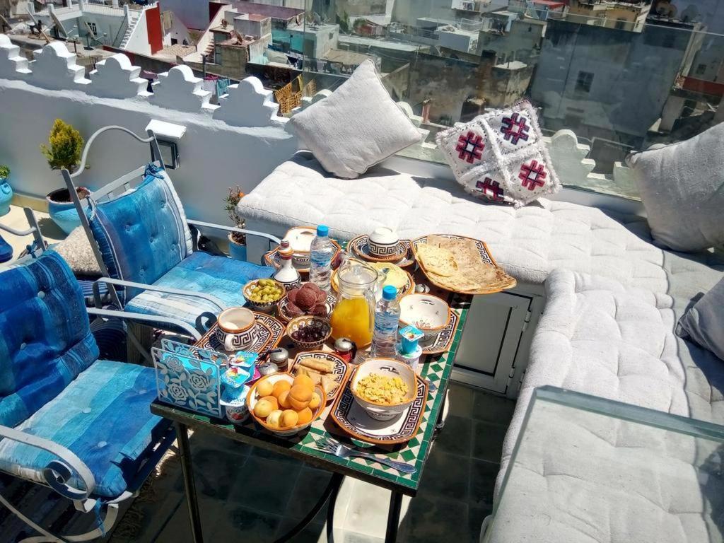 丹吉尔Dar Tinjâa的阳台上桌子上的托盘食物