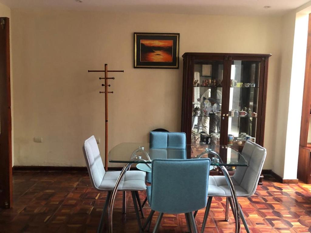 昆卡Mini departamento cómodo的一间设有玻璃桌和椅子的用餐室