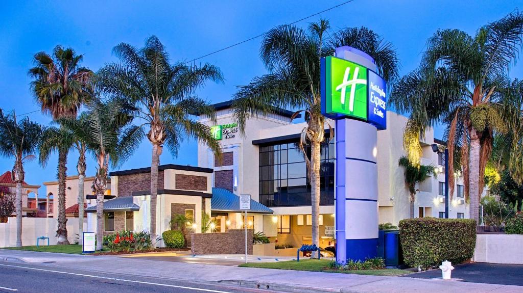 科斯塔梅萨Holiday Inn Express & Suites Costa Mesa, an IHG Hotel的前面有一个棕榈树的移动加油站