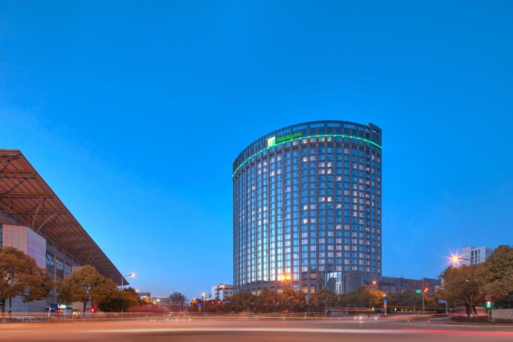 杭州杭州拱墅智选假日酒店的城市的一座高大的玻璃建筑