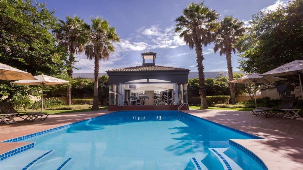 肯普顿帕克约翰内斯堡机场假日酒店的一个带凉亭和棕榈树的游泳池