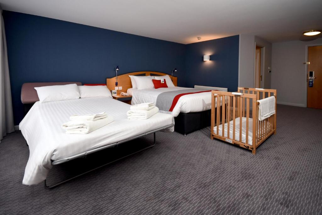利物浦快捷假日利物浦阿尔伯特码头酒店的酒店客房设有两张床和一张婴儿床。