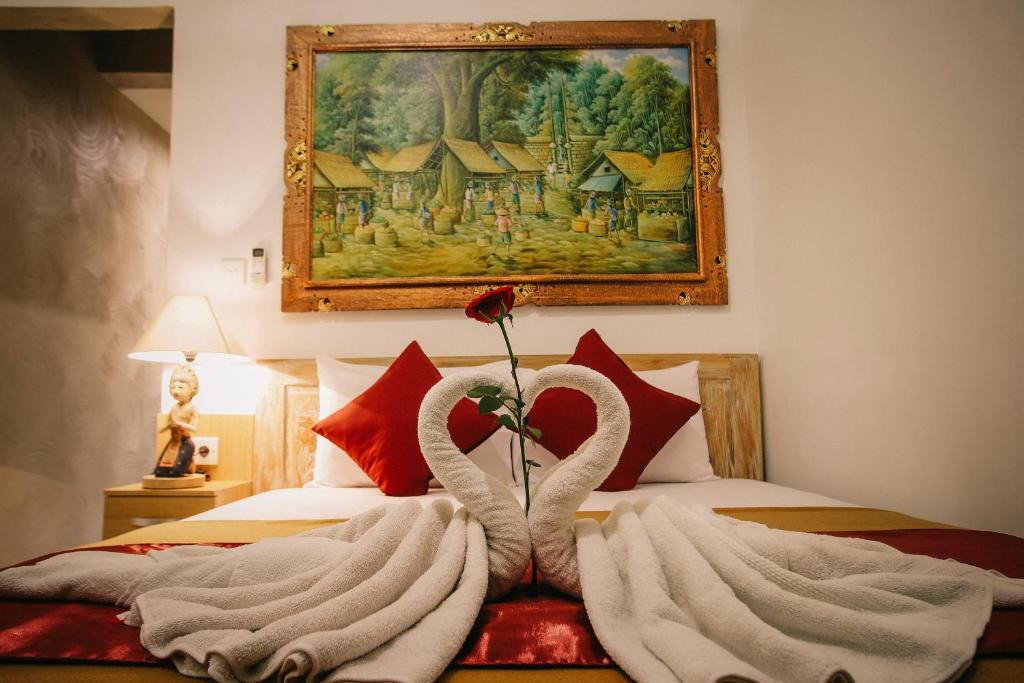 乌布乌布居苑旅馆的一间卧室配有一张带两只天鹅的毛巾床