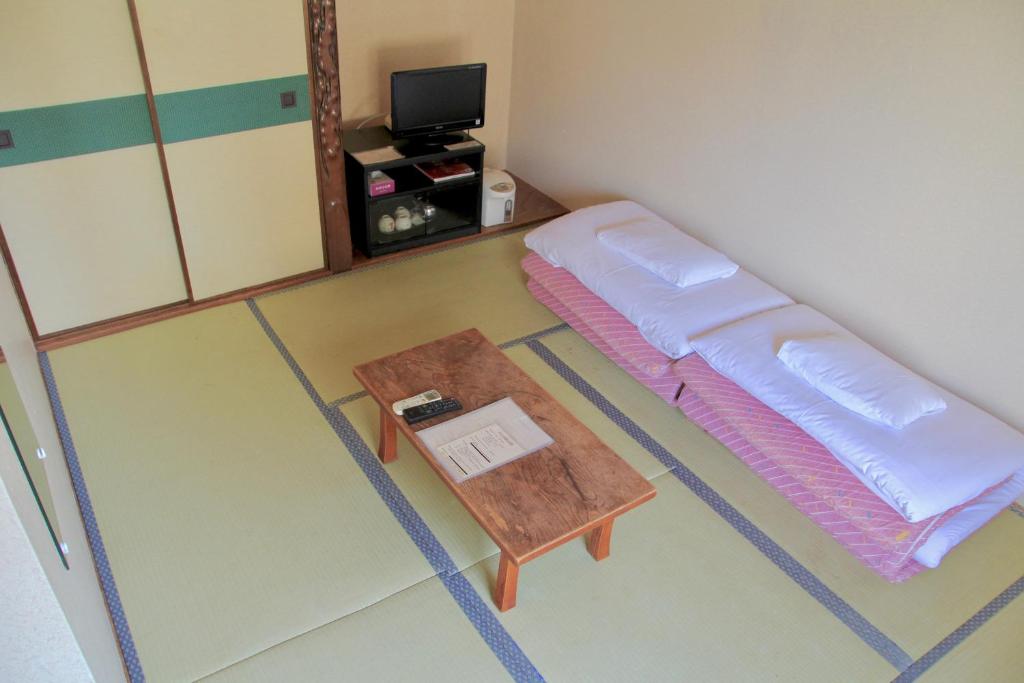 京都京都城市托米瑞奇住宿旅馆的小房间设有一张床和一张桌子