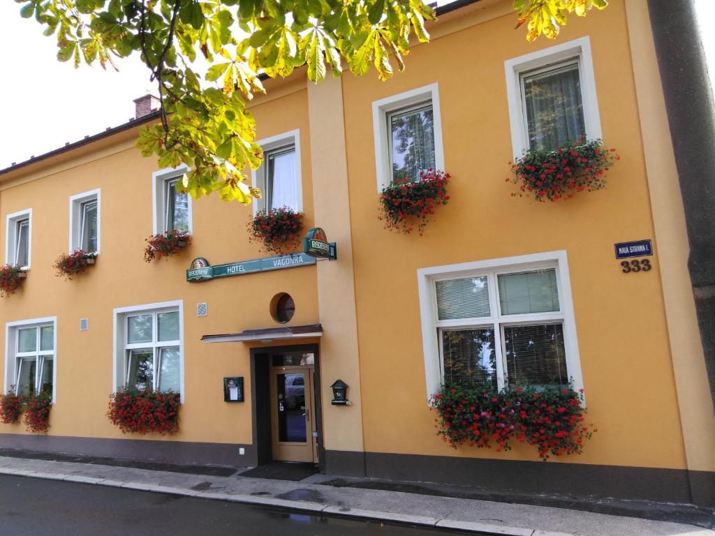 StudénkaHotel Vagónka的黄色建筑,窗户上放着花盒