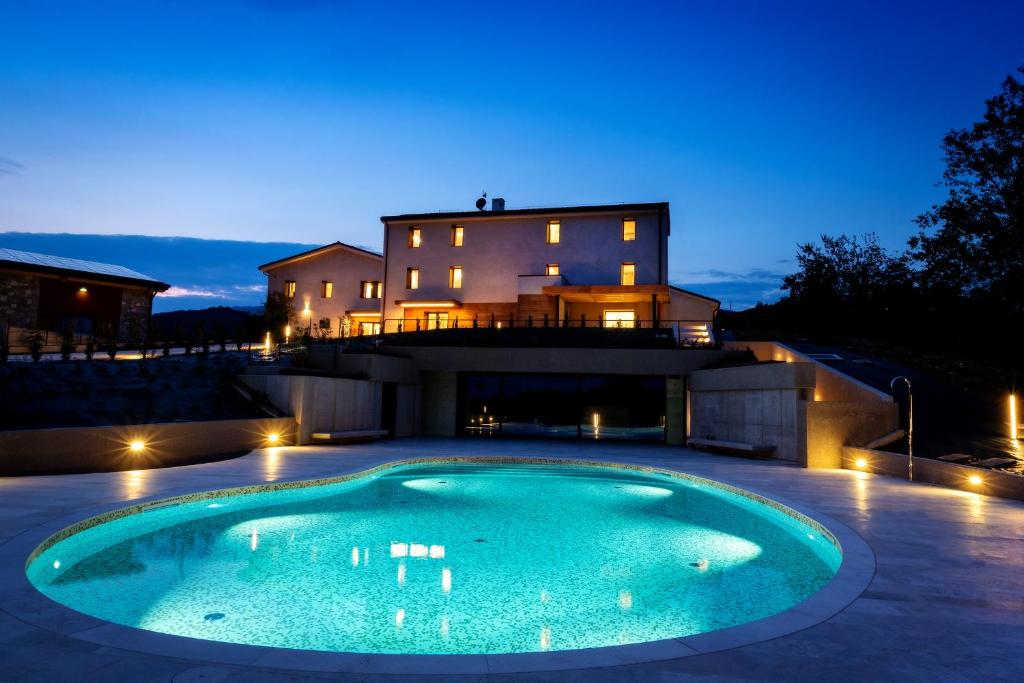 维托里奥·威尼托Relais Althea Azienda Agrituristica的夜间在房子前面的游泳池