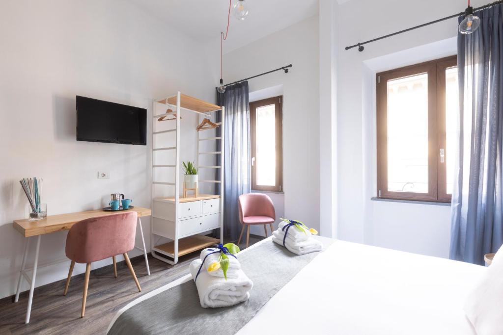 佛罗伦萨民间博物馆50米塞利酒店的一间卧室配有一张带两把椅子的床和一张书桌