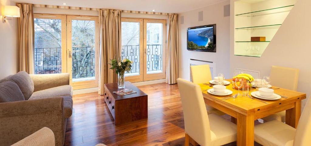 伦敦Tavistock Place Apartments的一间带桌子的客厅和一间餐厅