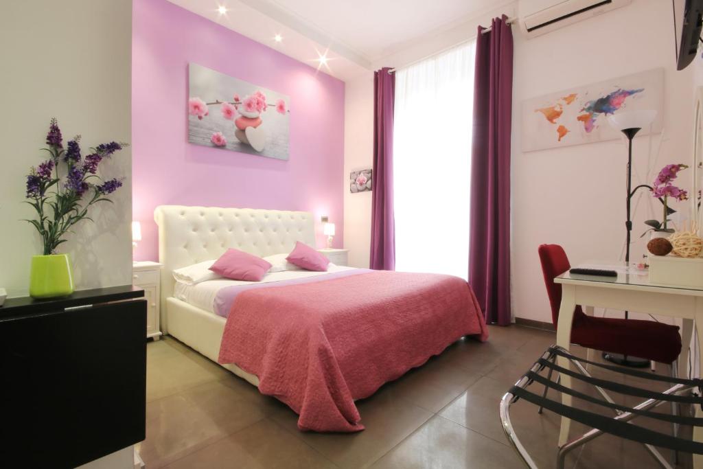 罗马梵蒂冈B＆B酒店的粉红色的卧室配有一张床和一张书桌