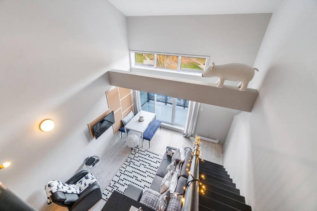 博普雷INITIAL - L'OURS - Mont-Sainte-Anne的客厅设有楼梯,享有高空的景色
