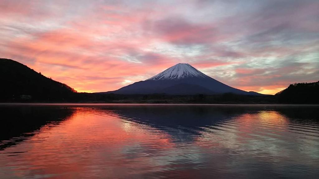 富士河口湖松杰山酒店的日落时分在水中反射的山