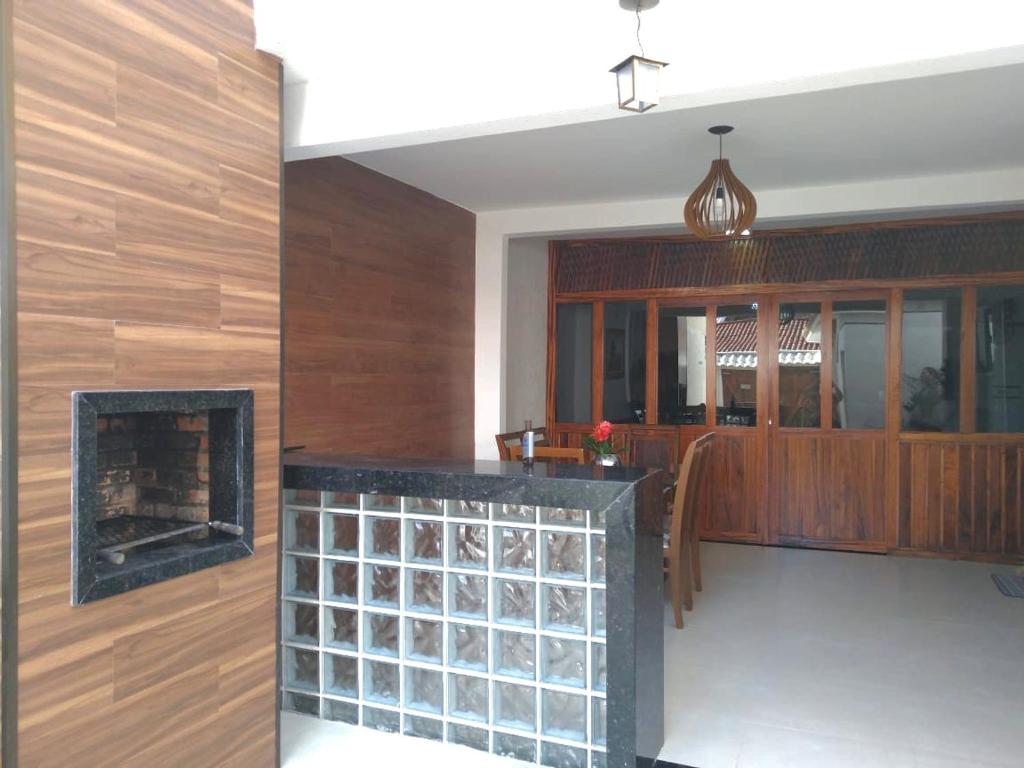 阿拉亚尔-杜卡布Bela casa的客厅设有壁炉和木墙