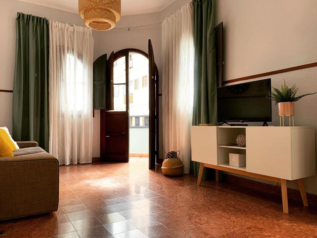 大加那利岛拉斯帕尔马斯Arrebol Vegueta的客厅配有电视、沙发和镜子