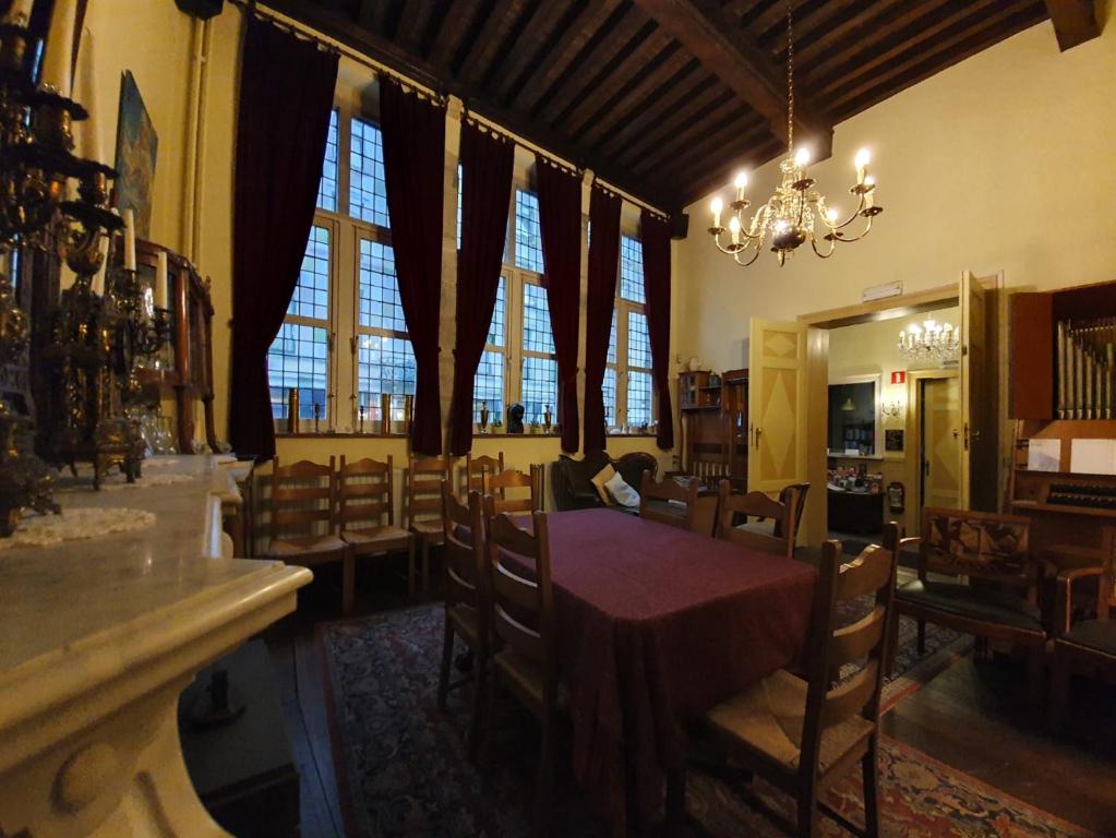 根特伊拉斯谟酒店的一间带桌椅和窗户的用餐室