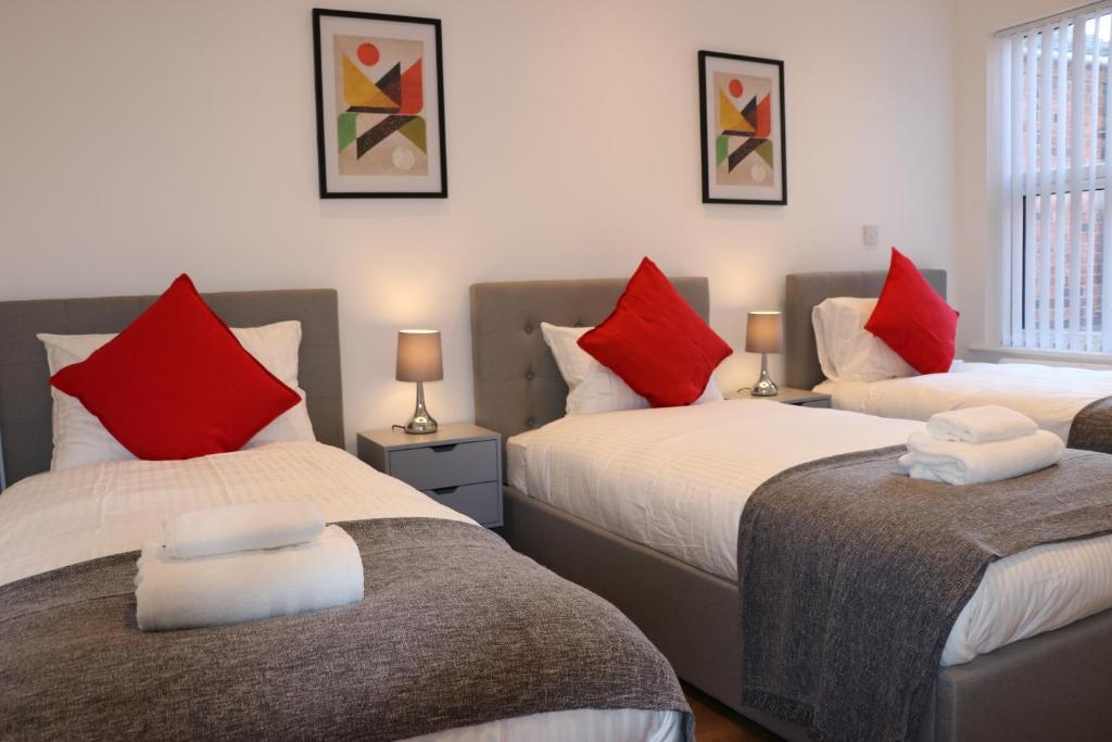 特伦特河畔斯托克Modern Newgate Apartments - Convenient Location, Close to All Local Amenities的一间卧室配有两张带红白色枕头的床