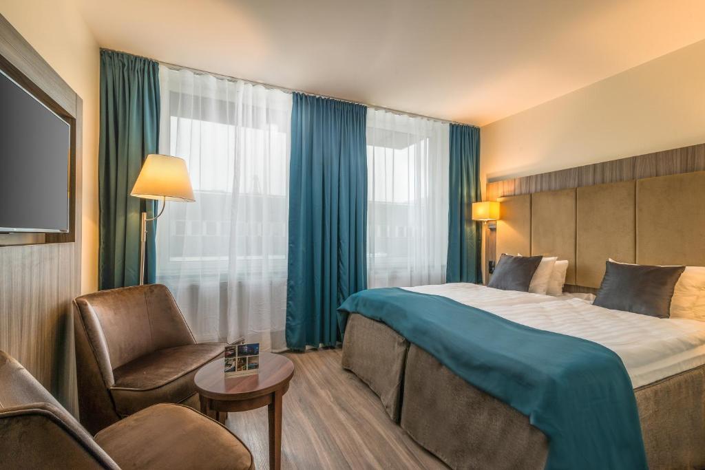 乌克瑟勒松德Hotel Oxelösund的配有一张床和一把椅子的酒店客房