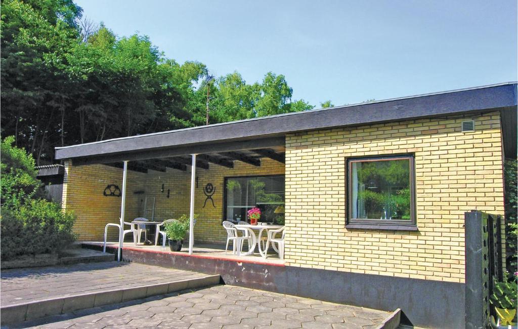 伦讷卡内加斯夫度假屋的一座黄色的小砖房子,配有桌椅