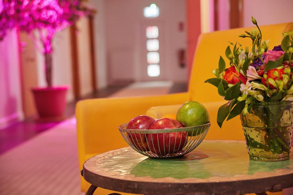 贝格海姆Joos Hotel的桌上一碗水果和花瓶