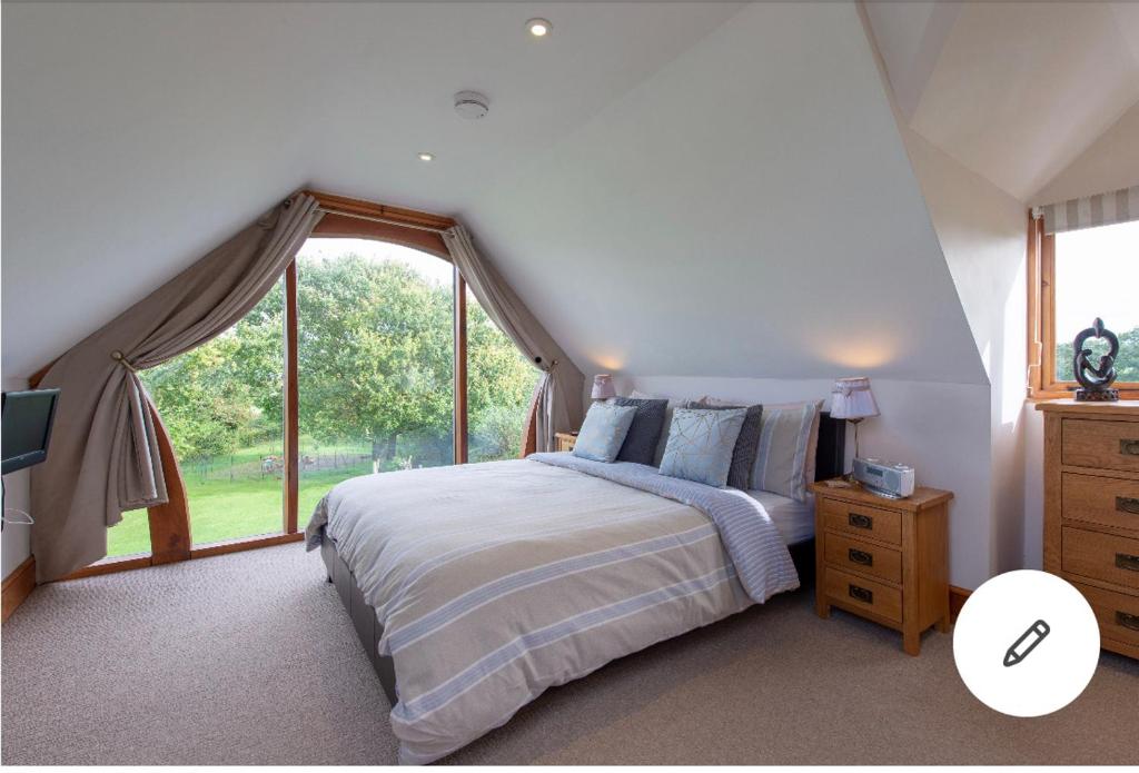 AngersleighThe Chalet Somerset的一间卧室设有一张床和一个大窗户
