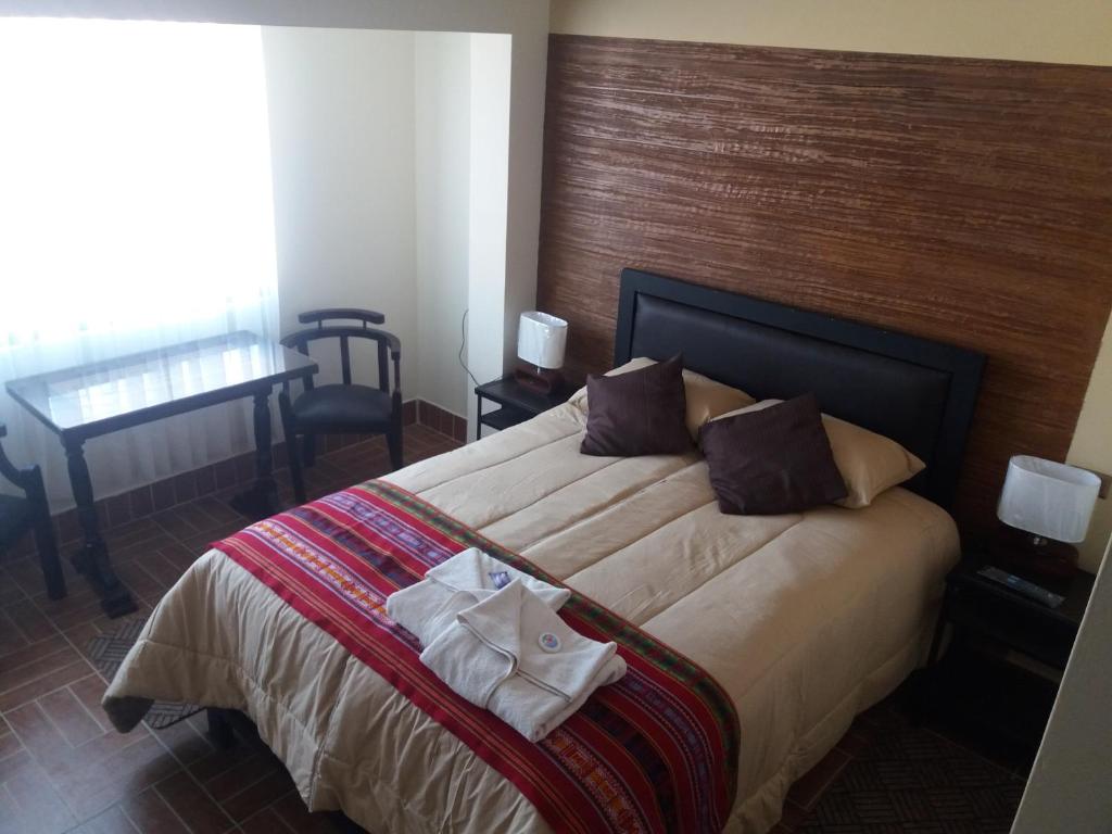 乌尤尼Hostal Jerian的一间卧室配有一张大床和木制床头板