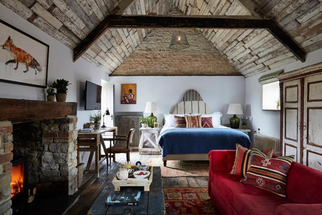 牛津牛津郡艺术家酒店的一间卧室设有一张床,客厅设有壁炉。