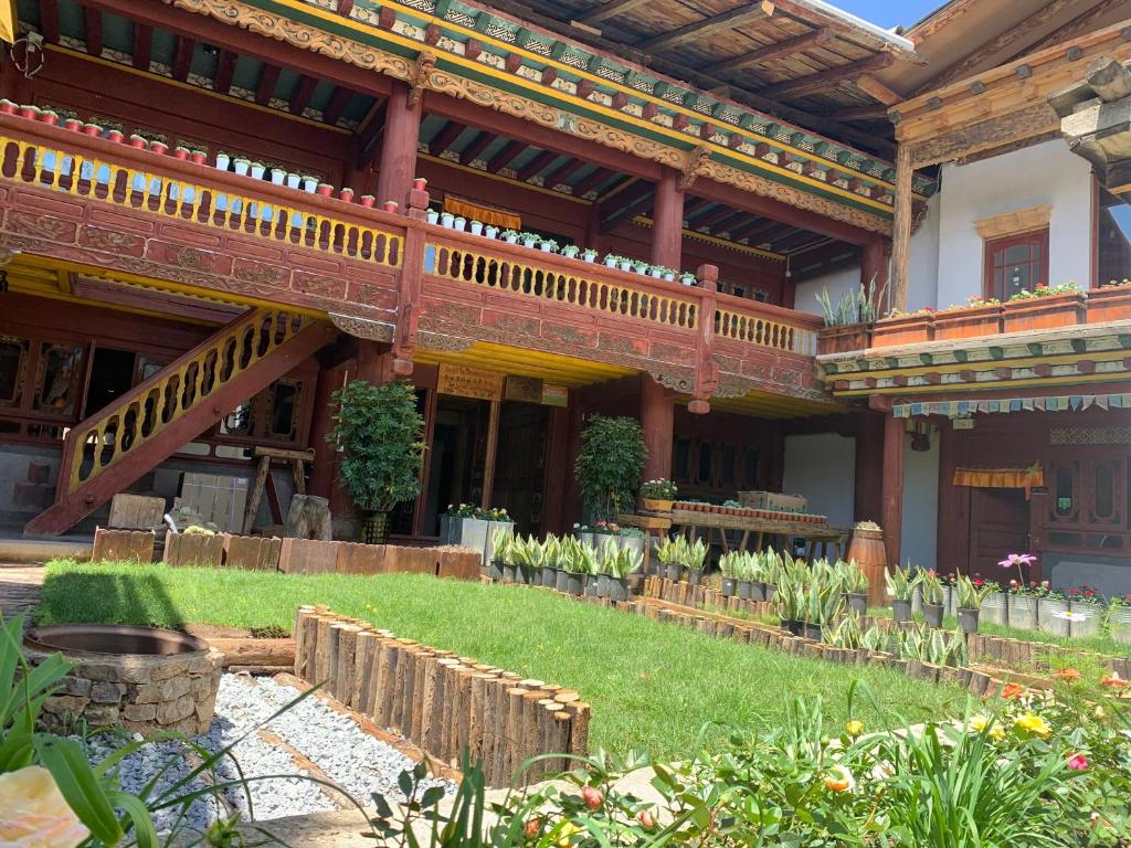 香格里拉香格里拉市香野听雨酒店的带阳台的建筑和鲜花盛开的花园